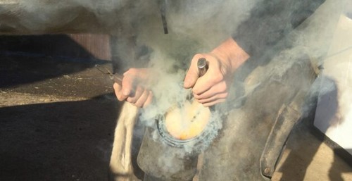 A farrier putting on a shoe