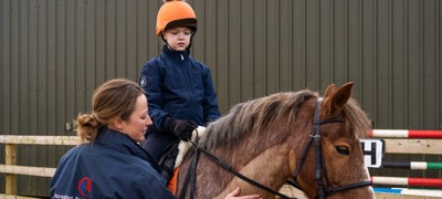 Accredited Professional Coach coaching child on horse