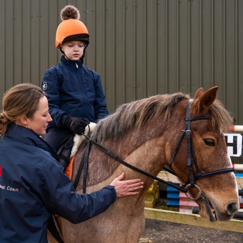 Accredited Professional Coach coaching child on horse