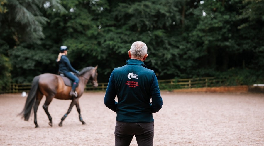 Male Coach Teaching A Rider And Horse