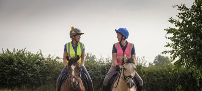 two smiling riders on horses