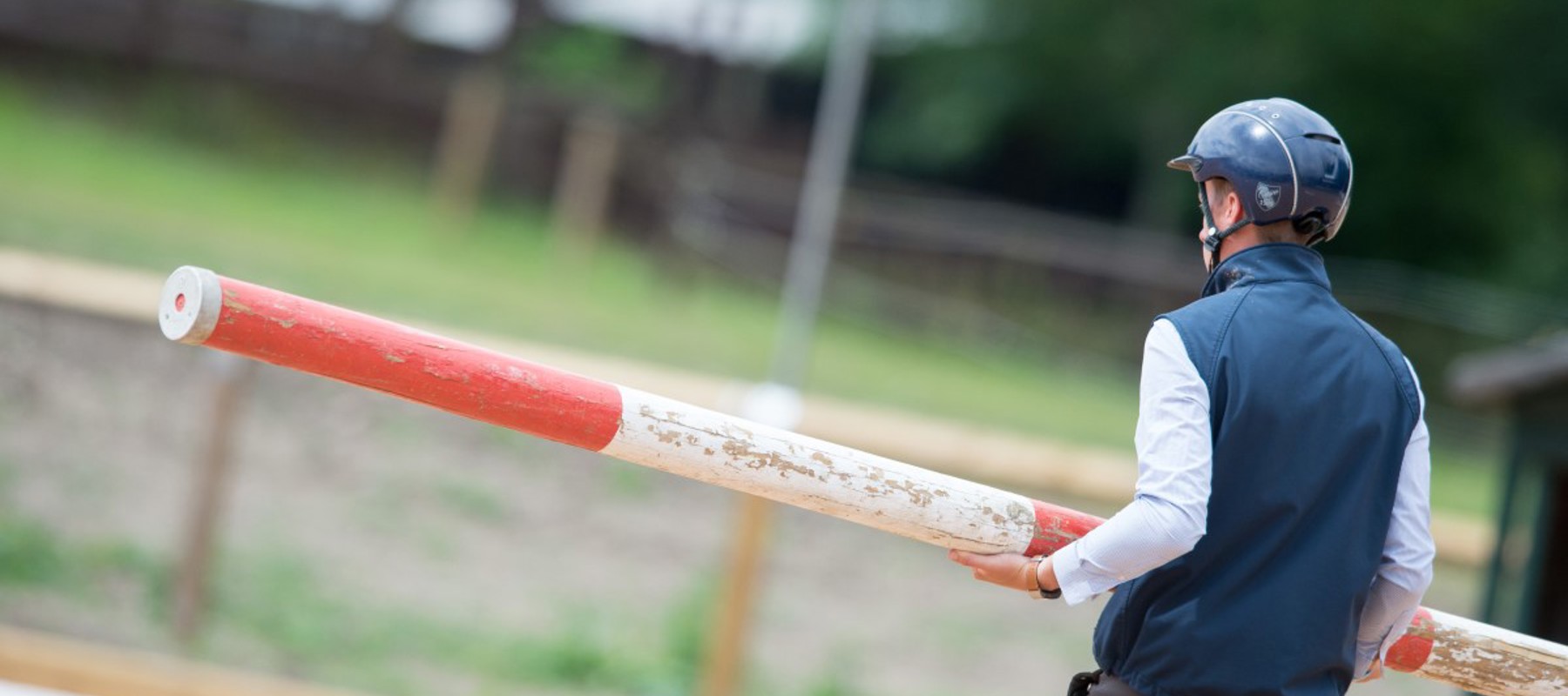 Coach holding a metal vertical jump pole