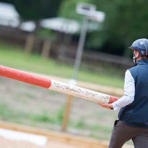 Coach holding a metal vertical jump pole