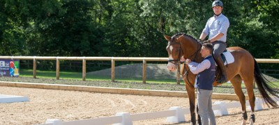 Coach and rider on a horse standing