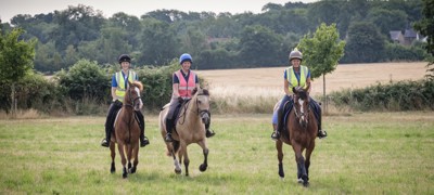 three smiling riders on horses