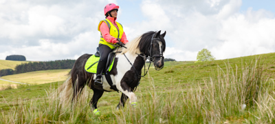 Rider and horse wearing hi-vis gear on MOD land