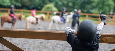 child watching riding lesson