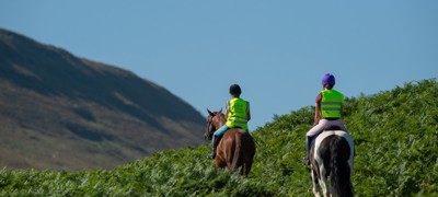 two riders on horses wearing BHS hi vis