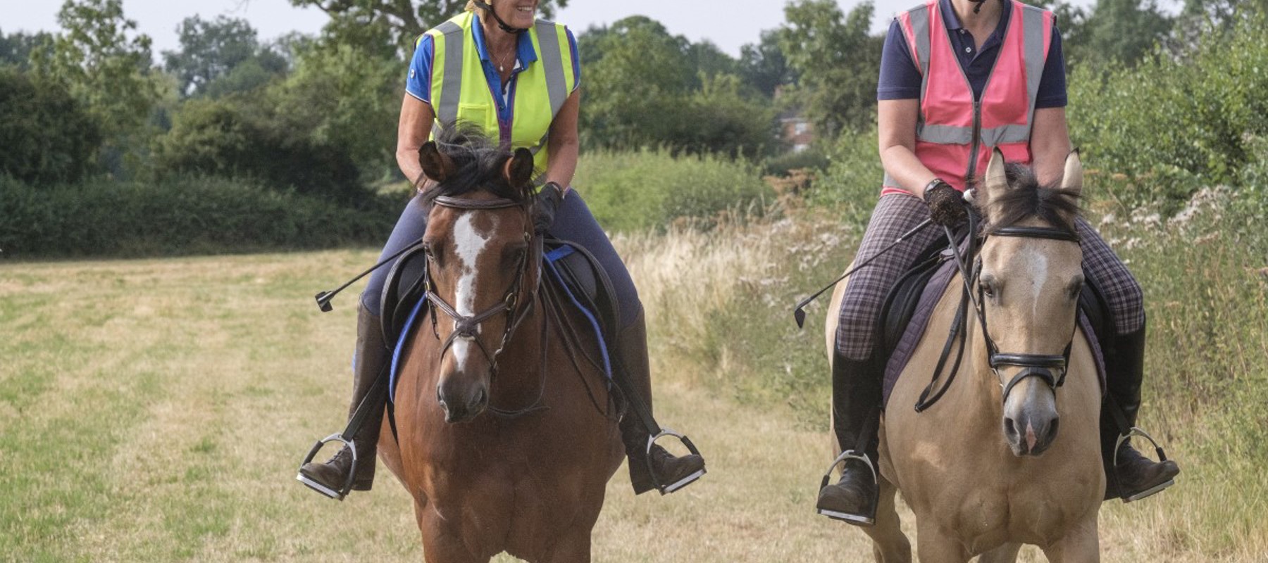 two smiling riders on horses