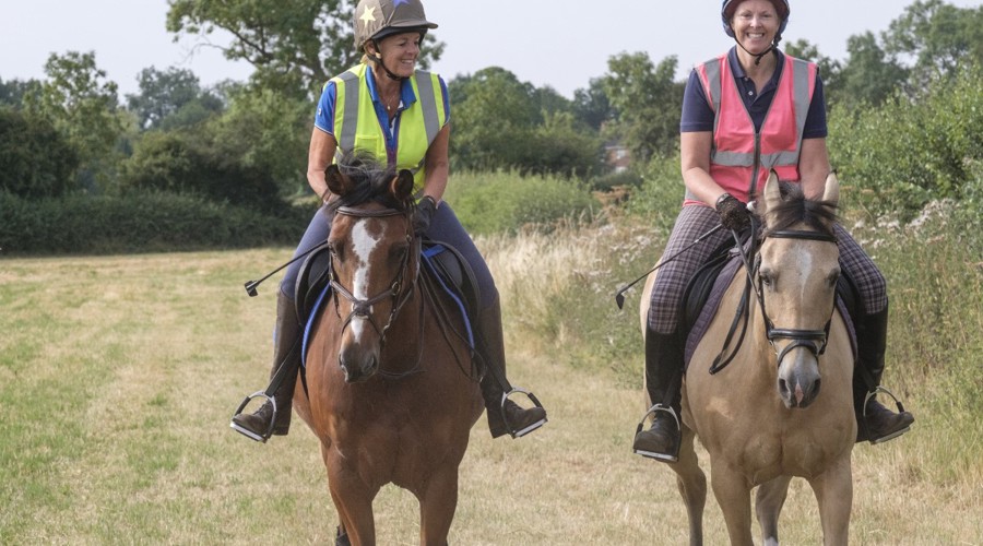 two smiling riders on horses