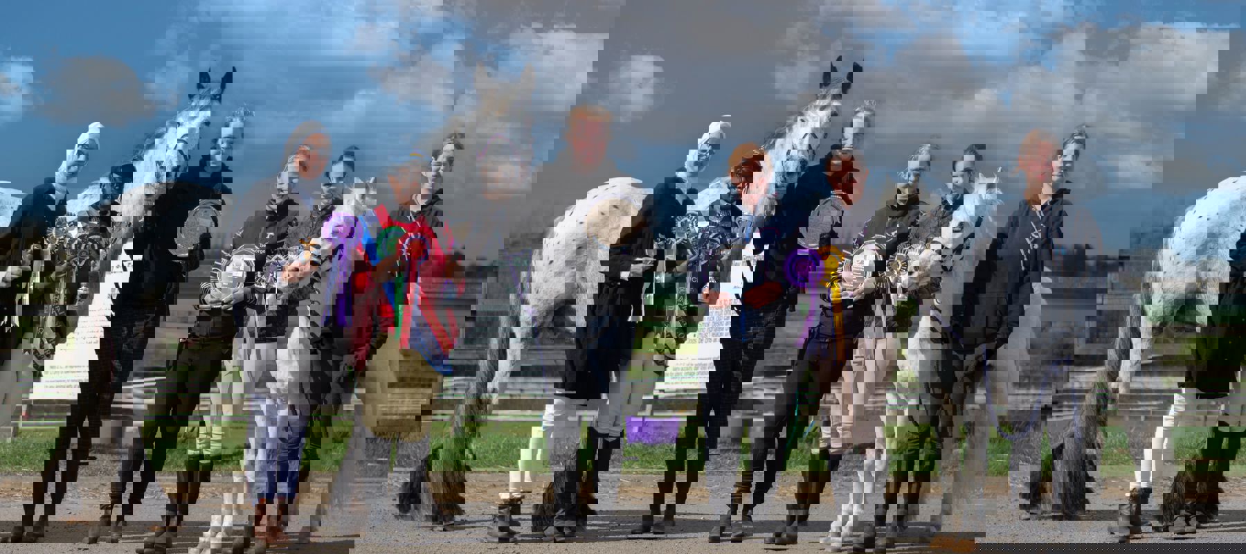 horse riders with horses showing rosettes