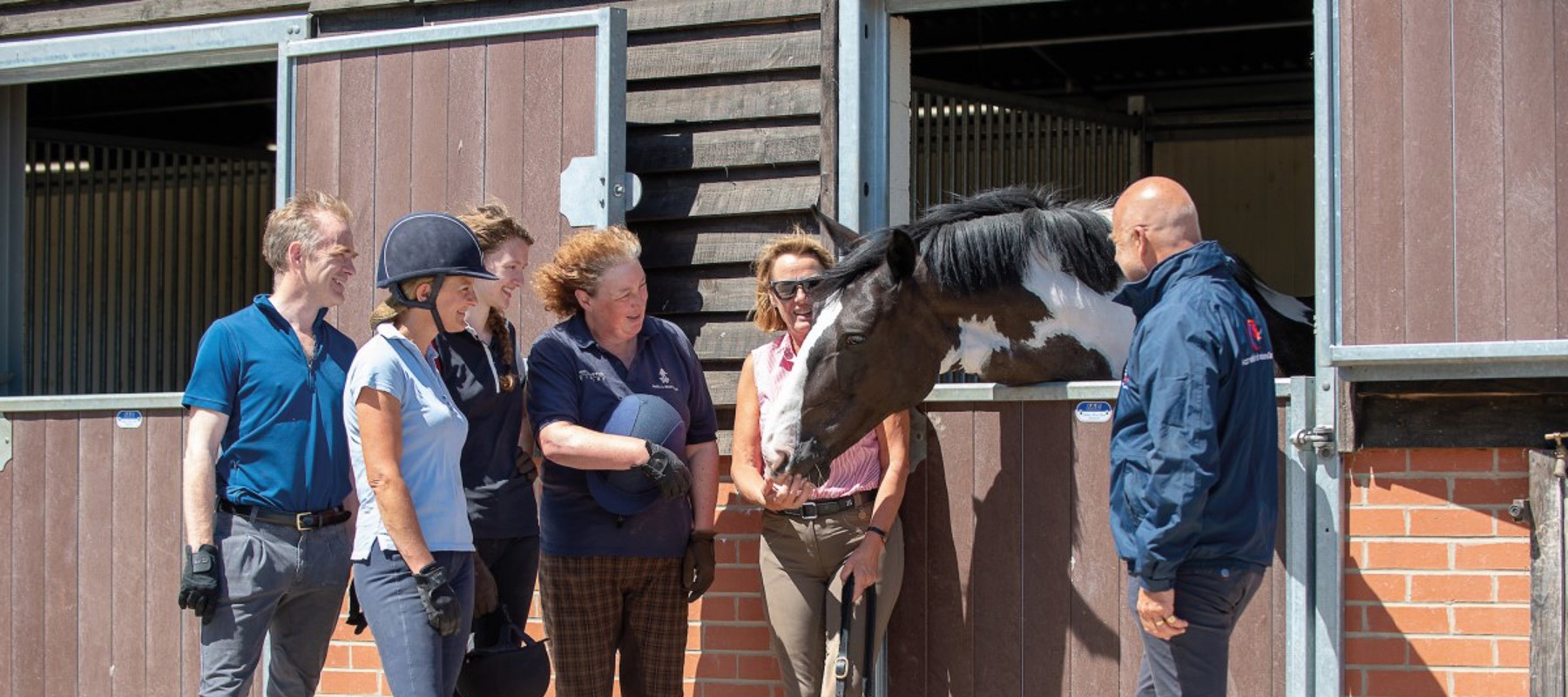 people and a horse in stables