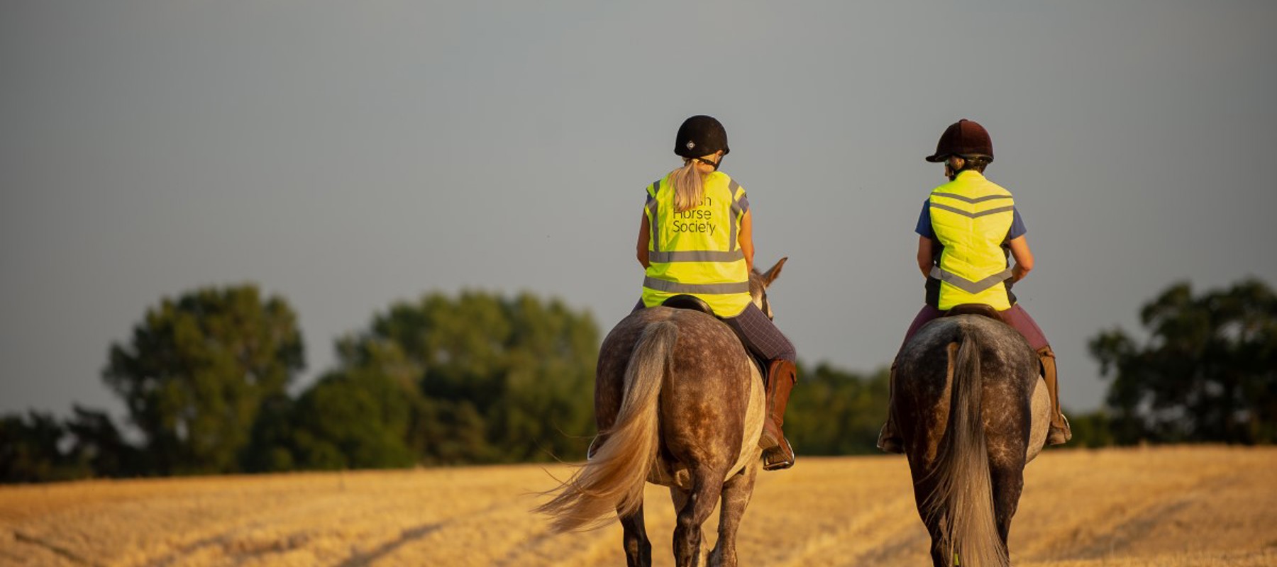 two riders riding out at sunset